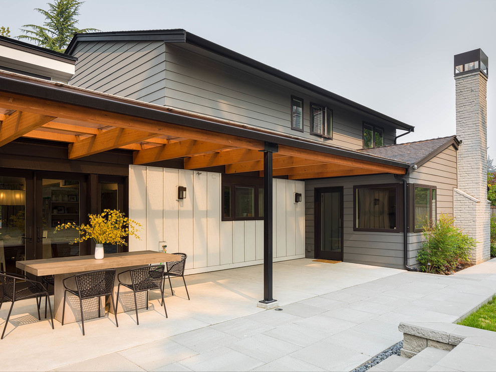 Immagine di un patio o portico tradizionale di medie dimensioni e dietro casa con pavimentazioni in cemento e un tetto a sbalzo