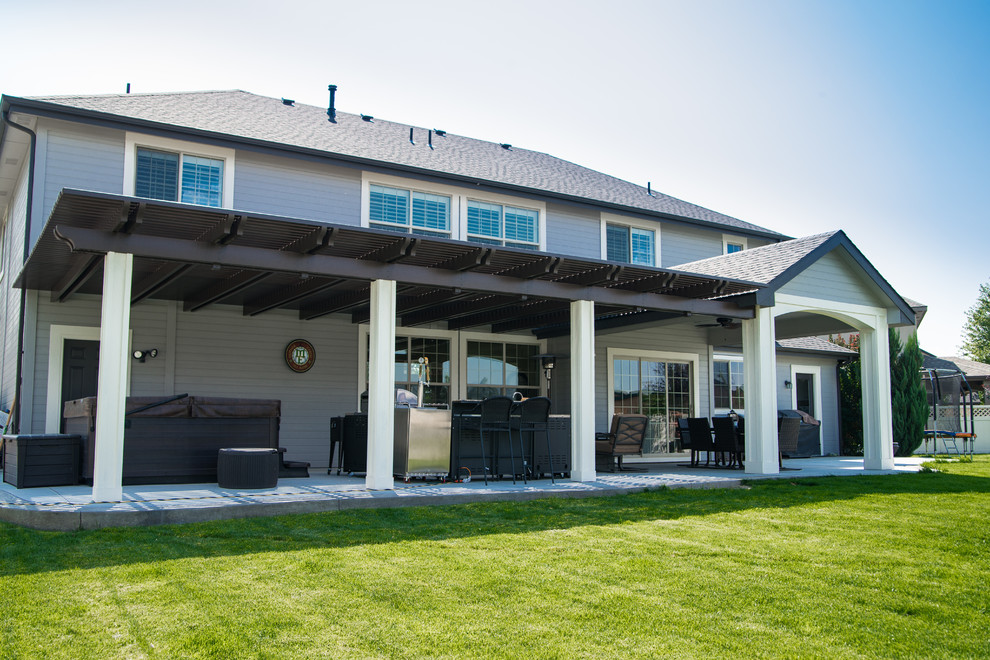 Large contemporary back patio in Boise with an outdoor kitchen and a pergola.