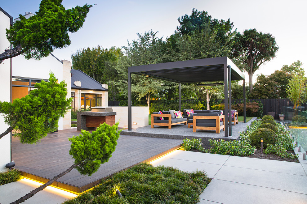 Ispirazione per un patio o portico minimal di medie dimensioni e dietro casa con lastre di cemento e una pergola
