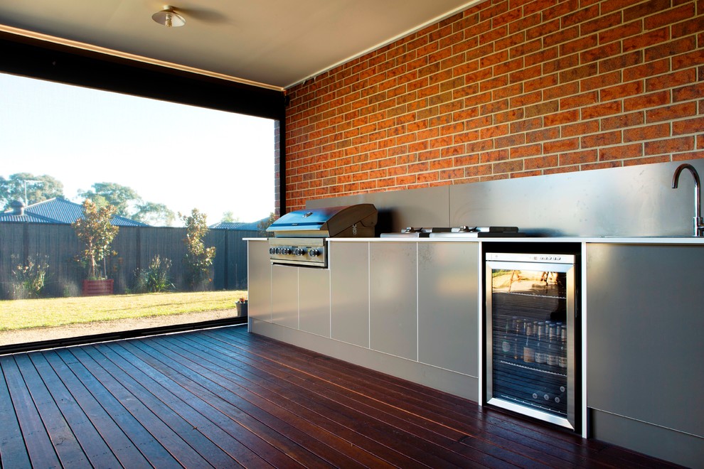 Diseño de patio minimalista grande en patio trasero y anexo de casas con cocina exterior y entablado
