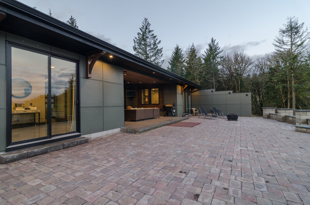 Стильный дизайн: большой двор на заднем дворе в стиле модернизм с мощением клинкерной брусчаткой и навесом - последний тренд
