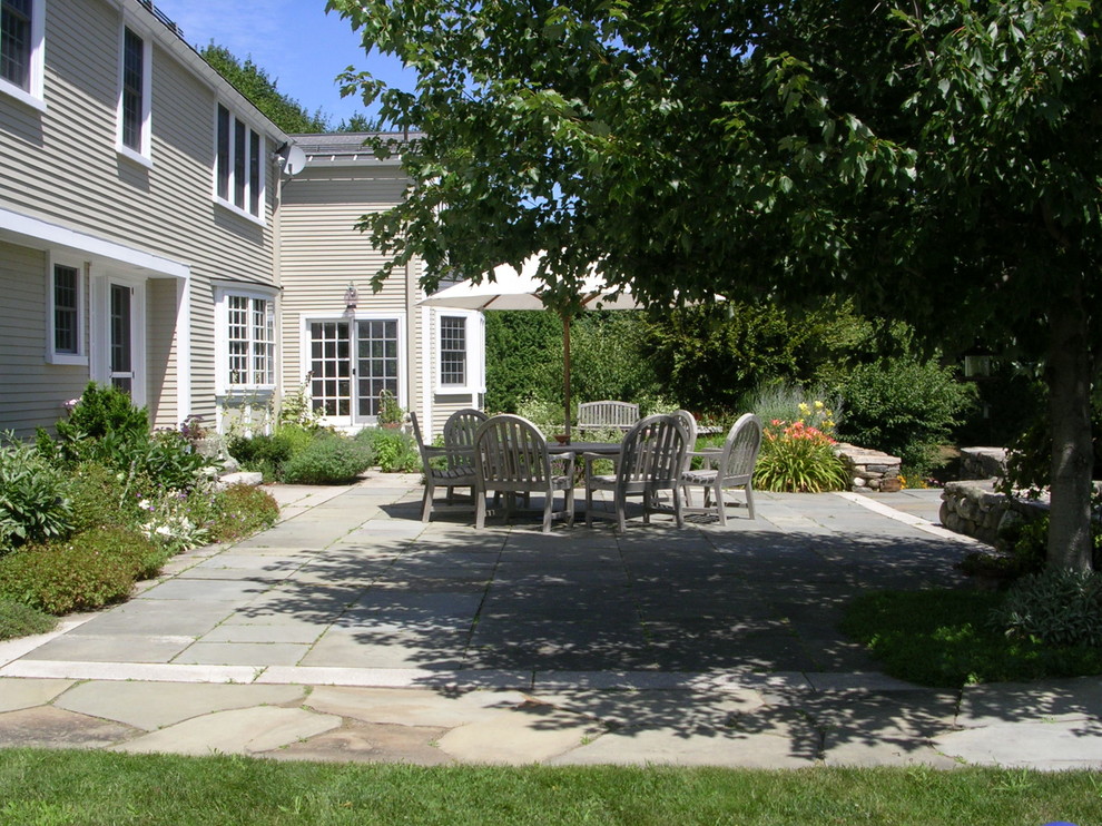 Photo of a large country back patio in Boston with natural stone paving.