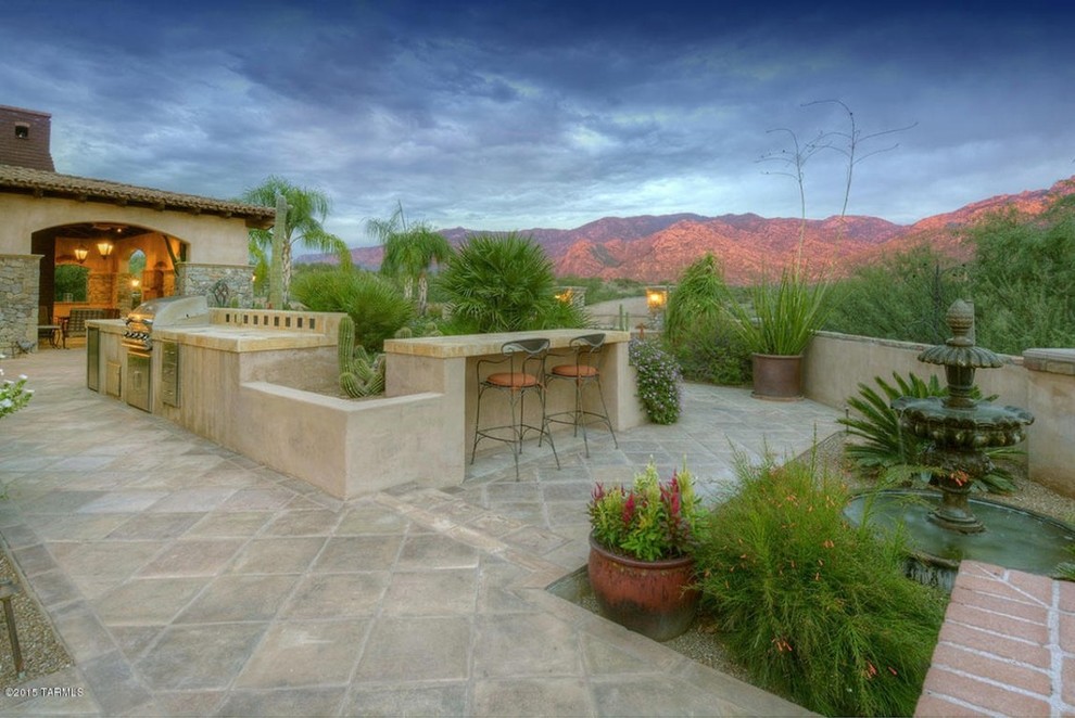 Immagine di un grande patio o portico american style dietro casa con un focolare e pavimentazioni in pietra naturale
