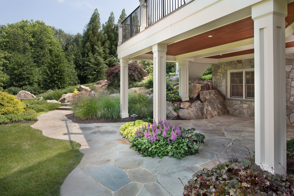 Пример оригинального дизайна: большой двор на заднем дворе в классическом стиле с покрытием из каменной брусчатки и навесом