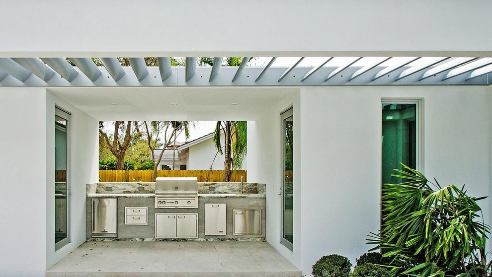 Пример оригинального дизайна: двор среднего размера на заднем дворе в стиле модернизм с летней кухней, мощением тротуарной плиткой и навесом