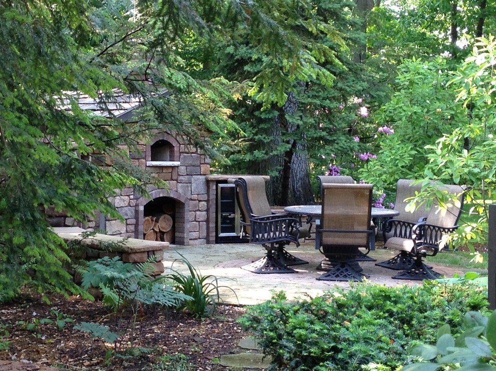 Photo of a medium sized traditional back patio in Detroit with natural stone paving and a fireplace.
