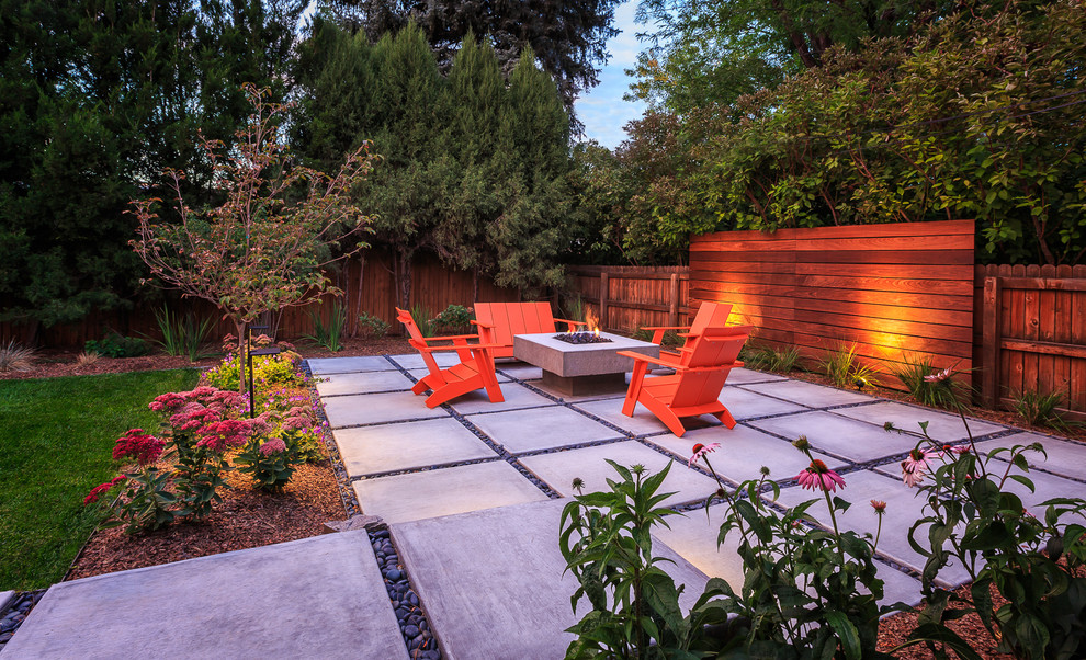 Esempio di un patio o portico minimalista di medie dimensioni e dietro casa con un focolare e pavimentazioni in cemento