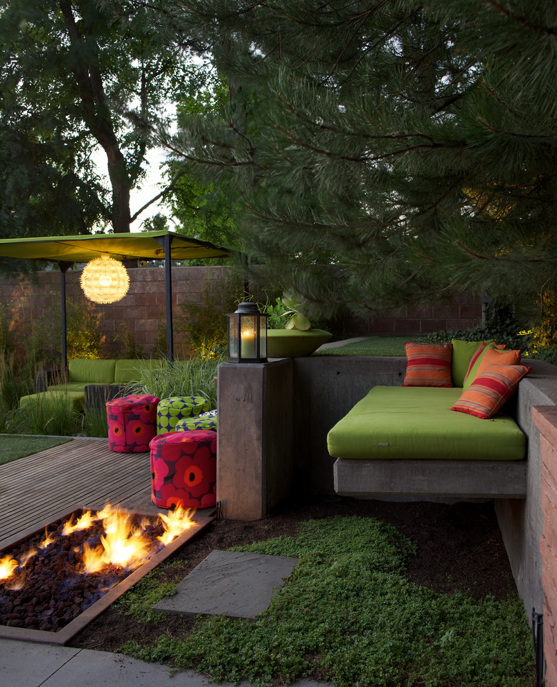 Immagine di un patio o portico minimalista con un focolare, pedane e un gazebo o capanno