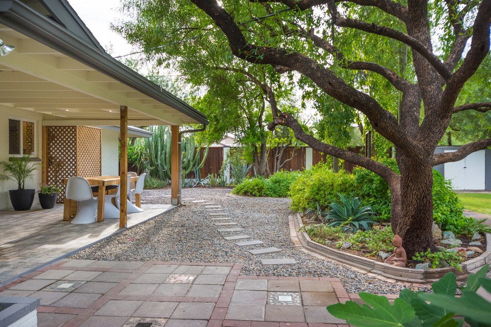 Foto di un grande patio o portico minimalista dietro casa con piastrelle e un tetto a sbalzo