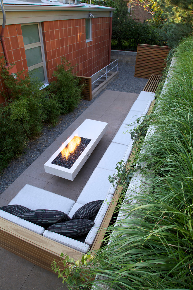 Immagine di un patio o portico moderno dietro casa e di medie dimensioni con un focolare, lastre di cemento e nessuna copertura