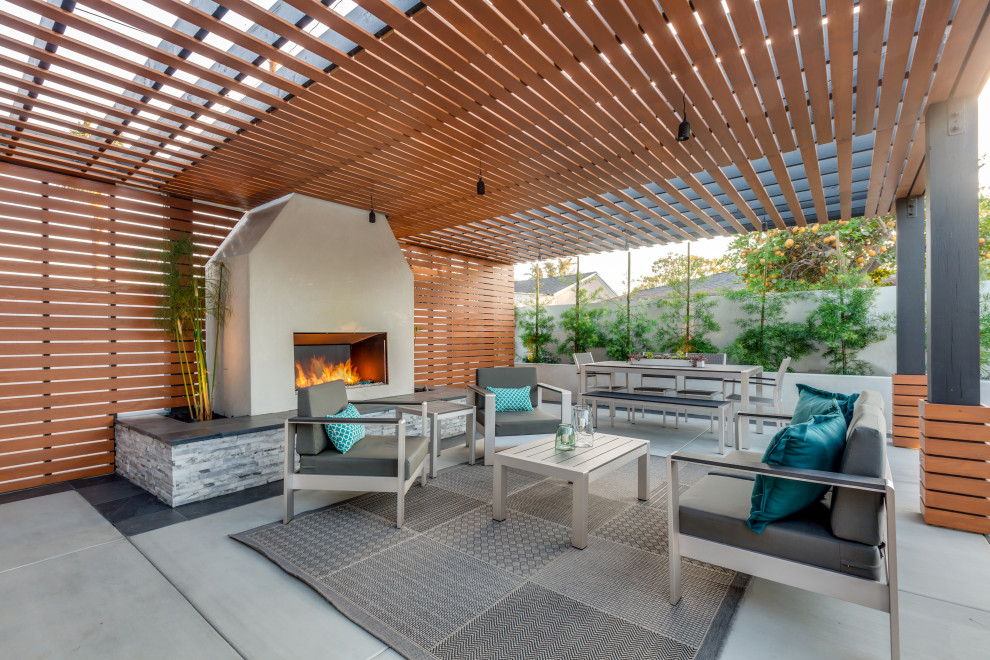 This is an example of a contemporary patio in Los Angeles with a fireplace and a pergola.