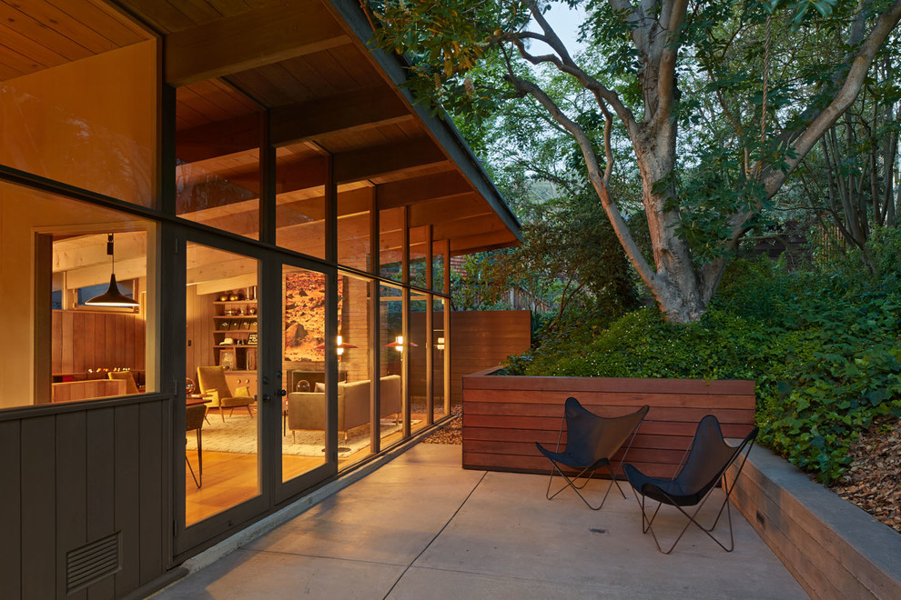Esempio di un patio o portico minimalista dietro casa con lastre di cemento