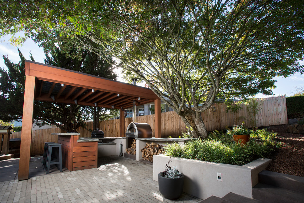 Geräumige Mid-Century Pergola hinter dem Haus mit Outdoor-Küche und Betonboden in Portland