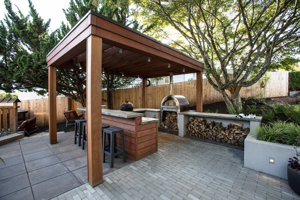 Exemple d'une très grande terrasse arrière rétro avec une cuisine d'été, des pavés en béton et une pergola.