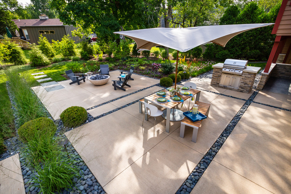 Modelo de patio minimalista de tamaño medio en patio trasero con losas de hormigón y brasero