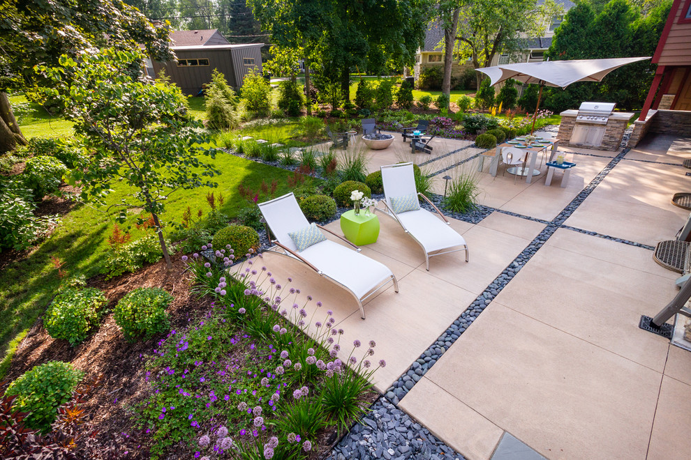Imagen de patio minimalista de tamaño medio en patio trasero con brasero y losas de hormigón