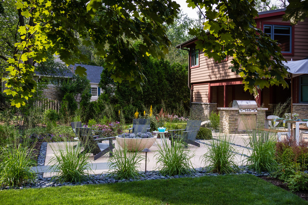 Diseño de patio minimalista de tamaño medio en patio trasero con brasero y losas de hormigón