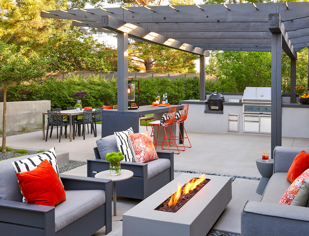 This is an example of a retro back patio in Denver with concrete slabs, a pergola and a bar area.