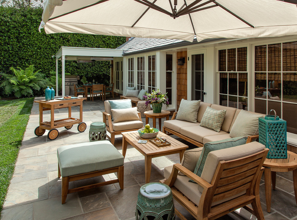 Large traditional back patio in Los Angeles with no cover and natural stone paving.