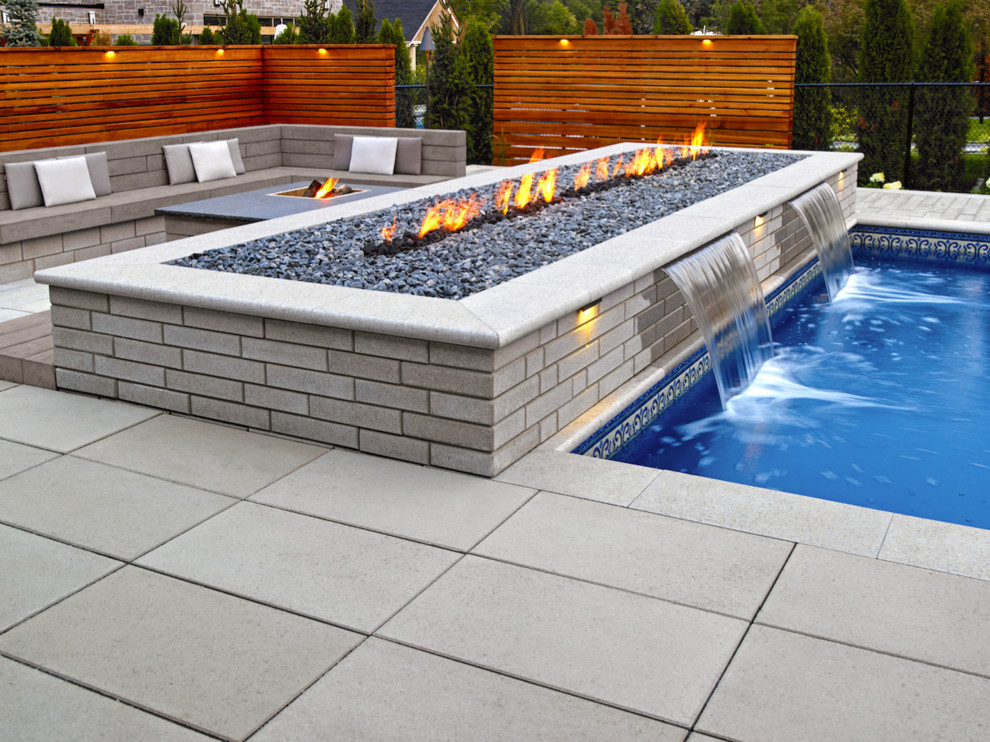 Inspiration for a large 1960s backyard concrete patio remodel in Toronto with a fire pit and no cover