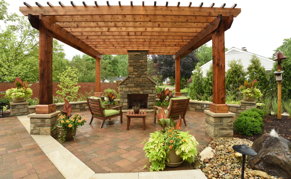 Large classic back patio in Columbus with brick paving and a pergola.