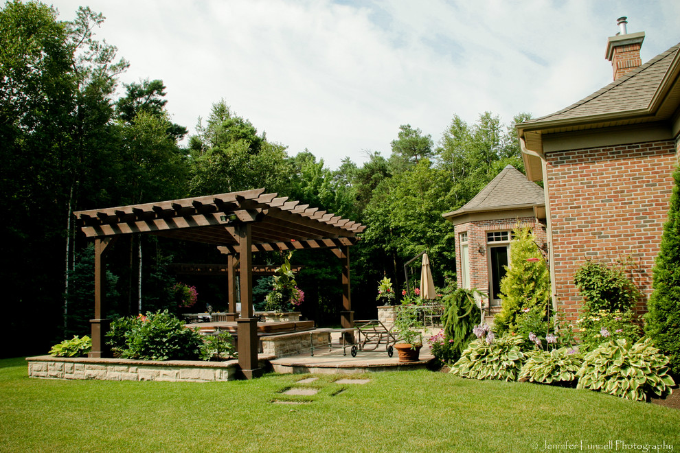 Große Klassische Pergola hinter dem Haus mit Wasserspiel und Natursteinplatten in Toronto