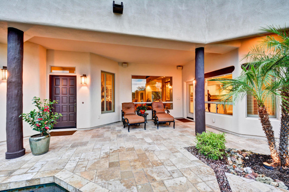 Inspiration for a large back patio in Phoenix with tiled flooring and a roof extension.