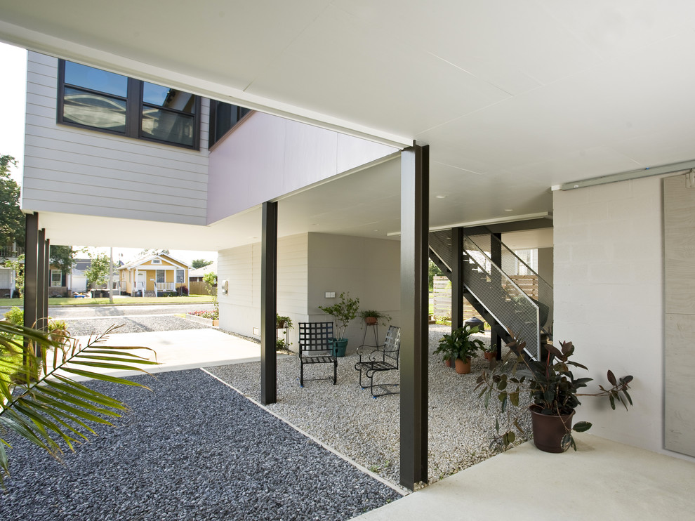 Diseño de patio contemporáneo en anexo de casas con gravilla