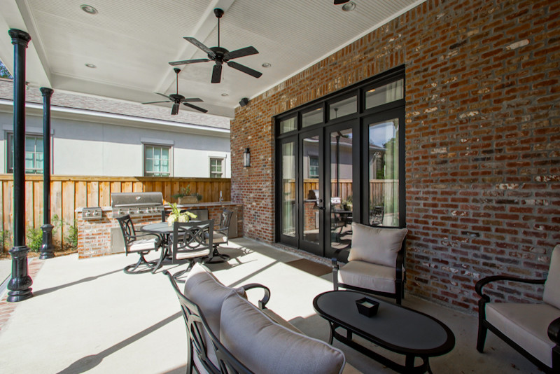 На фото: двор на заднем дворе в современном стиле с летней кухней, покрытием из бетонных плит и навесом с