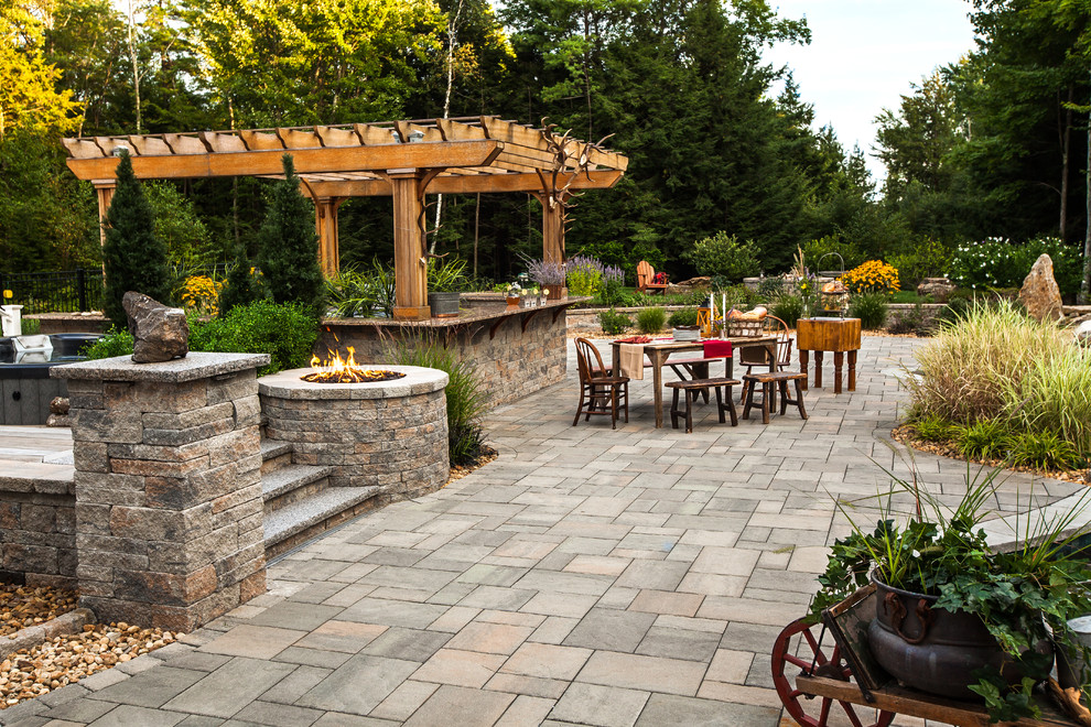 Cette image montre une grande terrasse arrière chalet avec une cuisine d'été et une dalle de béton.