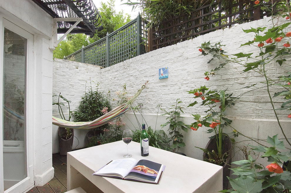 Ejemplo de patio contemporáneo de tamaño medio sin cubierta en patio con jardín de macetas y entablado