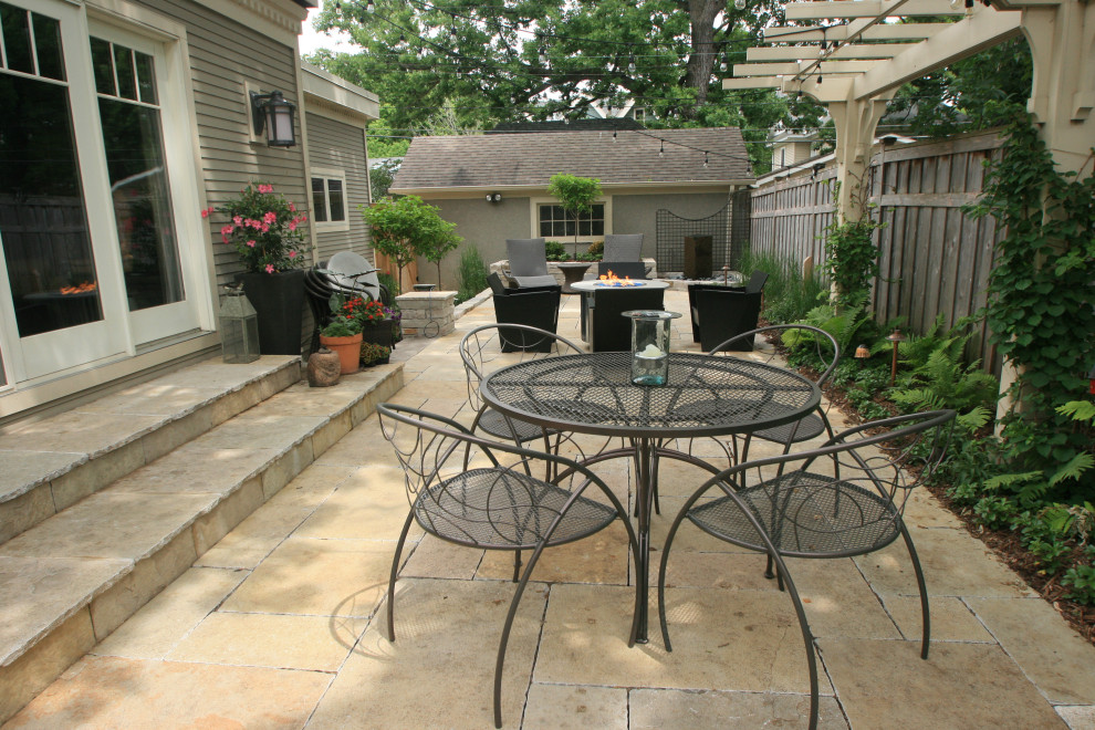Patio - small mediterranean courtyard stone patio idea in Minneapolis with a fire pit and a pergola