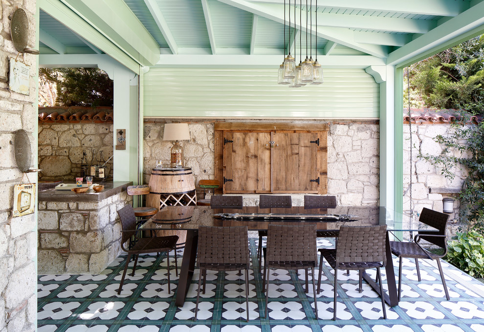 This is an example of a mediterranean patio in Orange County with an outdoor kitchen, tiled flooring and a pergola.