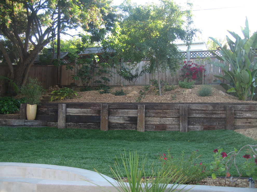 Imagen de patio de estilo americano de tamaño medio sin cubierta en patio trasero con jardín vertical y adoquines de ladrillo