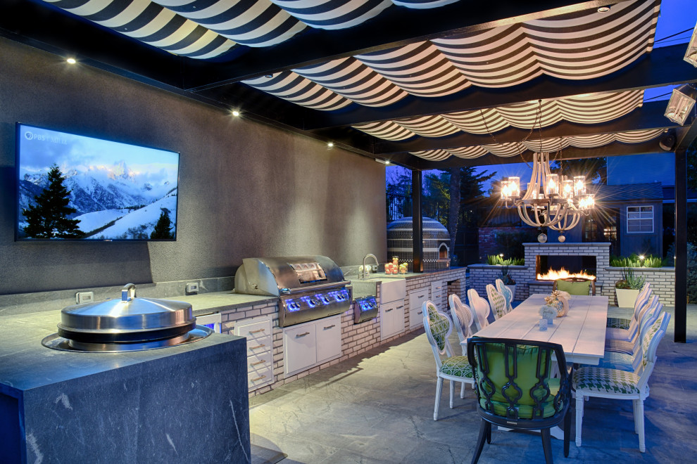 Moderne Pergola hinter dem Haus mit Outdoor-Küche und Natursteinplatten in San Diego