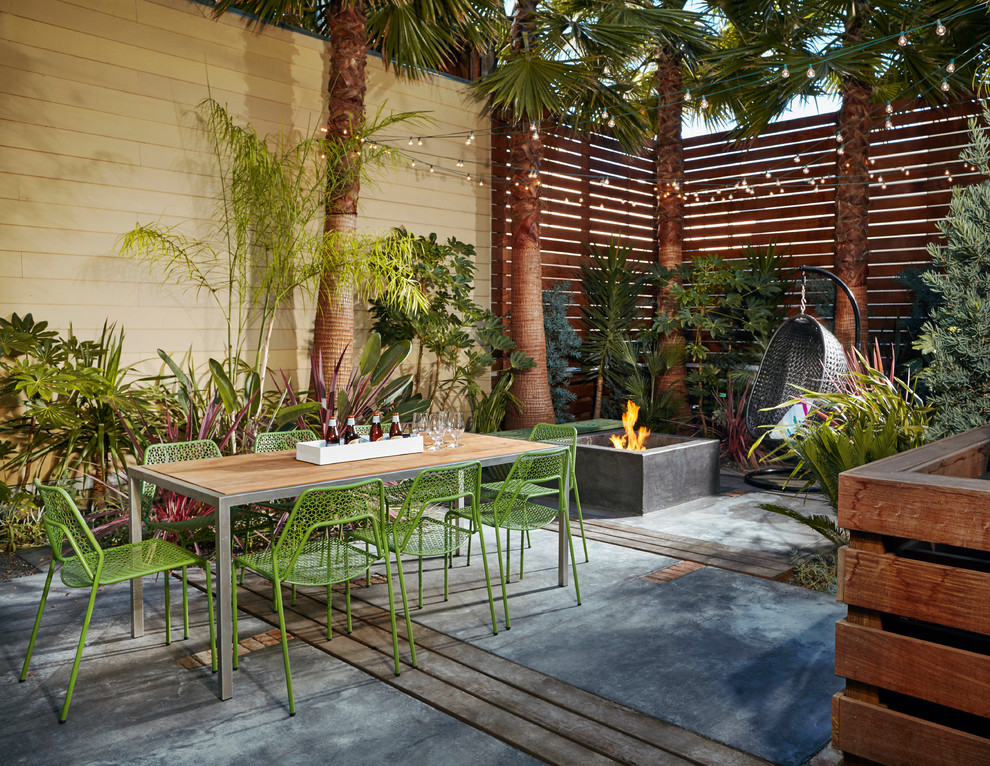 Стильный дизайн: двор среднего размера в стиле фьюжн с местом для костра и покрытием из бетонных плит без защиты от солнца - последний тренд