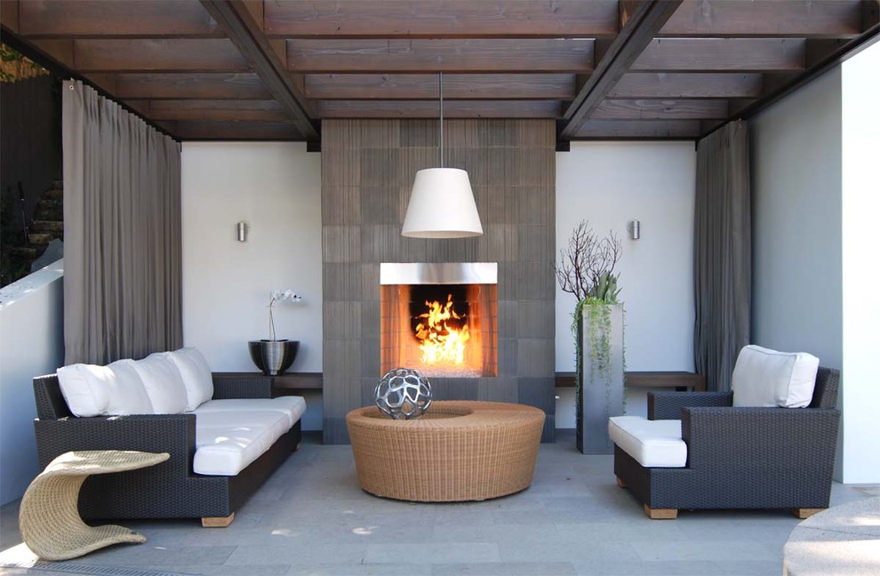 This is an example of a contemporary patio in Los Angeles with a fire feature and a pergola.