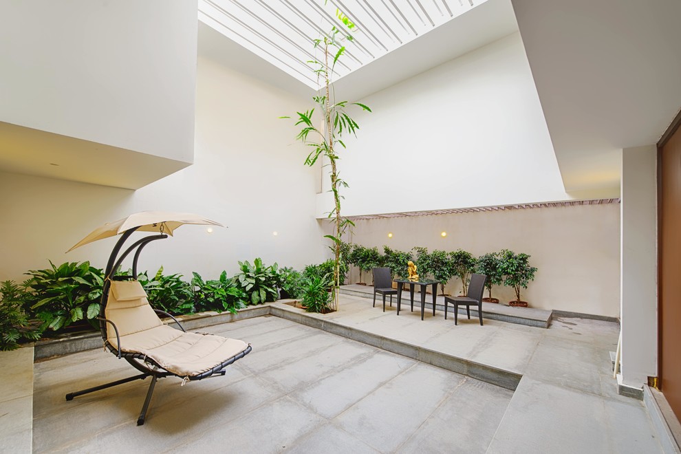 Esempio di un patio o portico minimal di medie dimensioni e in cortile con un giardino in vaso e lastre di cemento
