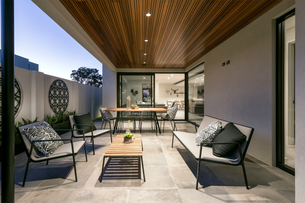 Example of a trendy concrete paver patio design in Perth with a roof extension