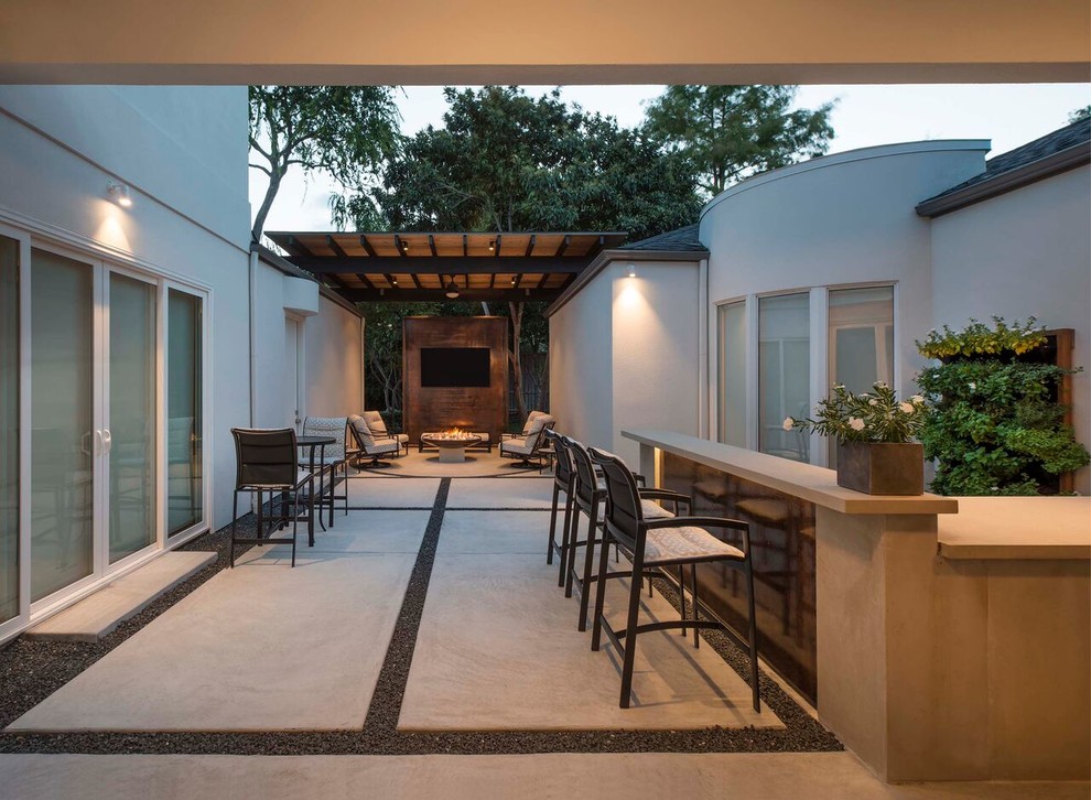 Inspiration pour une grande terrasse arrière minimaliste avec un foyer extérieur, des pavés en béton et un gazebo ou pavillon.