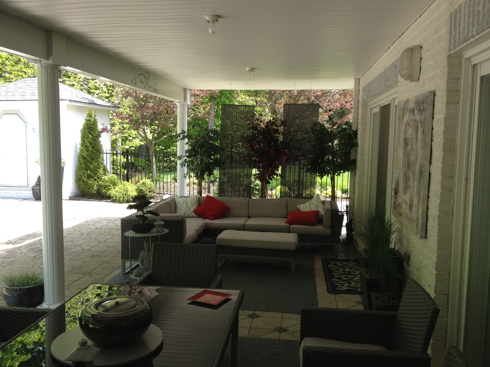 На фото: двор среднего размера на заднем дворе в восточном стиле с мощением тротуарной плиткой и навесом