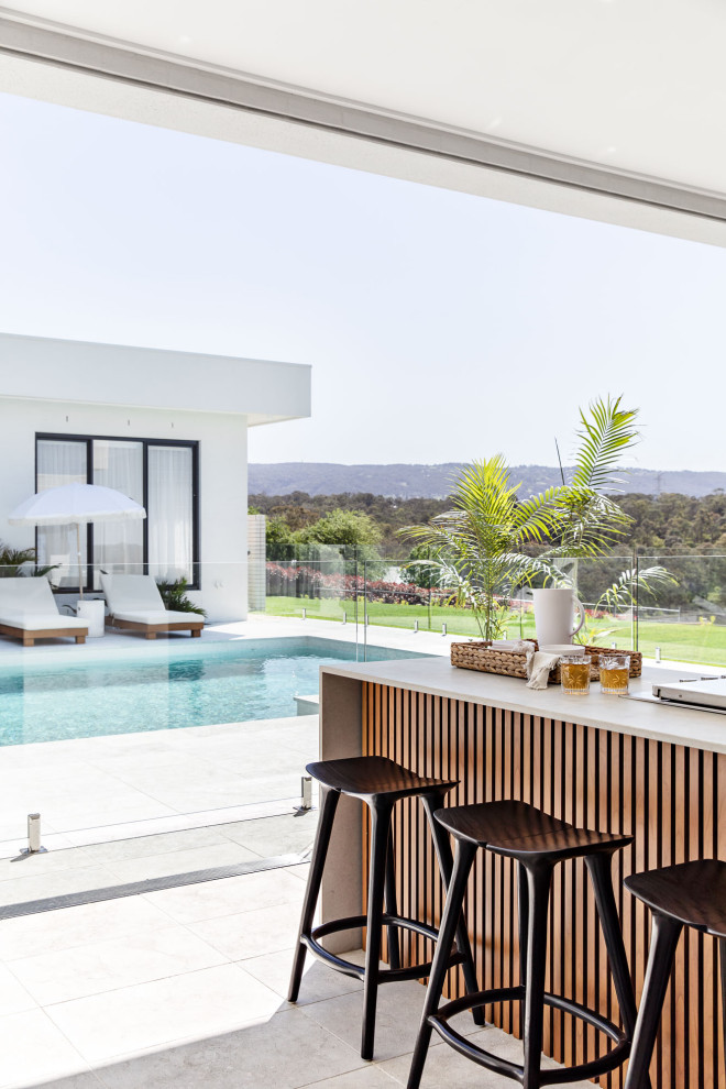 Idées déco pour une très grande terrasse arrière moderne avec une cuisine d'été, des pavés en béton et une extension de toiture.