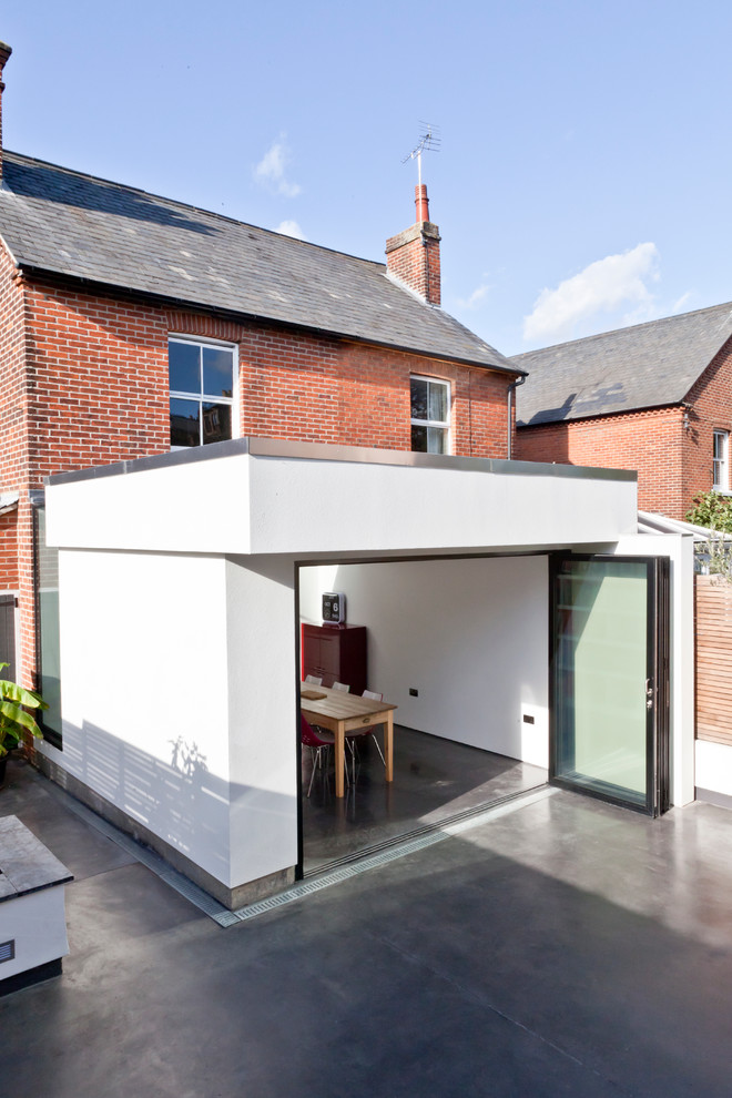 Esempio di un grande patio o portico minimalista con lastre di cemento e un tetto a sbalzo
