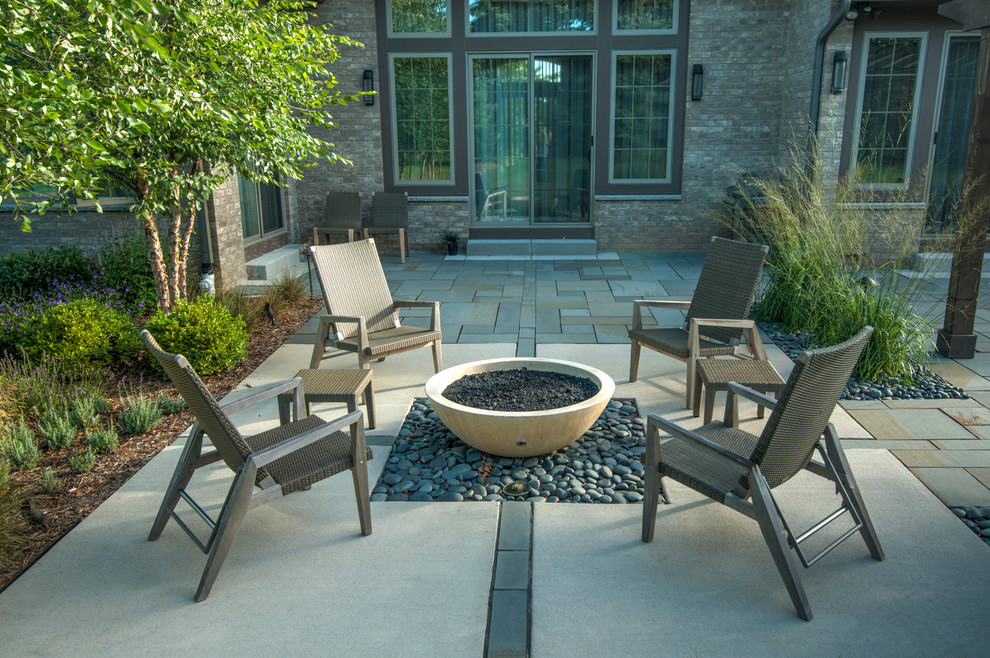 Diseño de patio moderno de tamaño medio en patio trasero con brasero, adoquines de piedra natural y pérgola