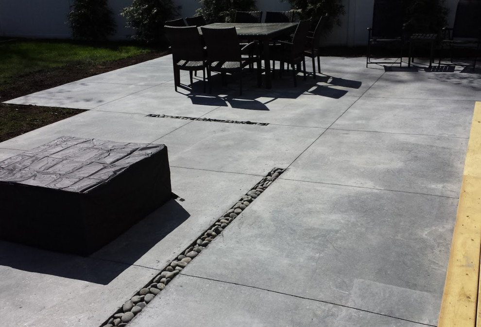 Medium sized modern back patio in New York with concrete slabs.