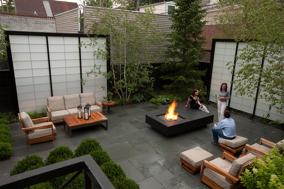 Photo of a small modern back patio in Chicago with a fire feature, tiled flooring and no cover.