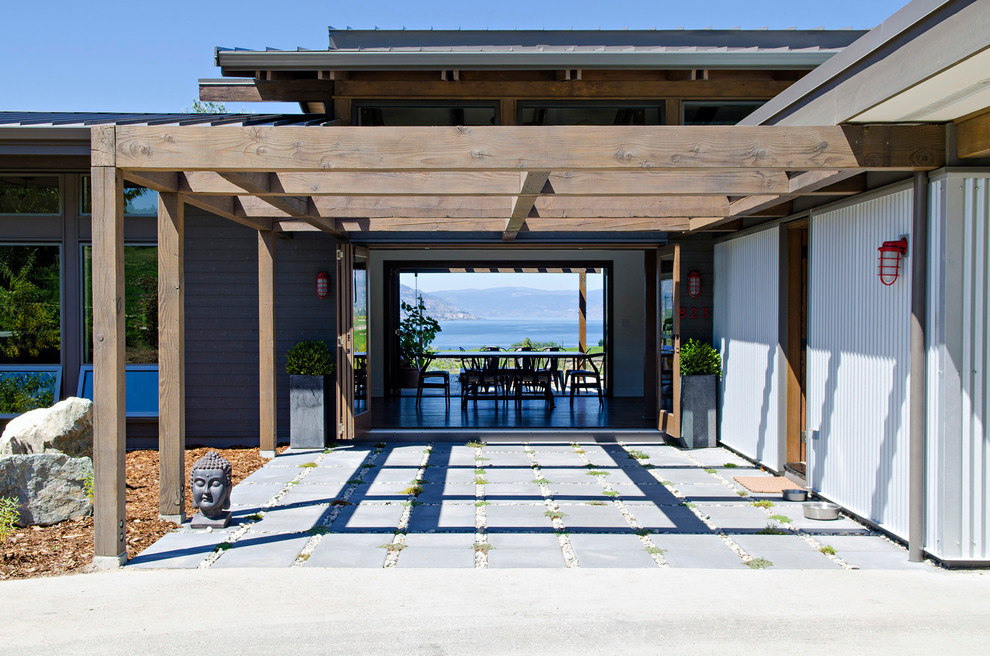 This is an example of a medium sized contemporary back patio in Vancouver with a pergola and concrete paving.