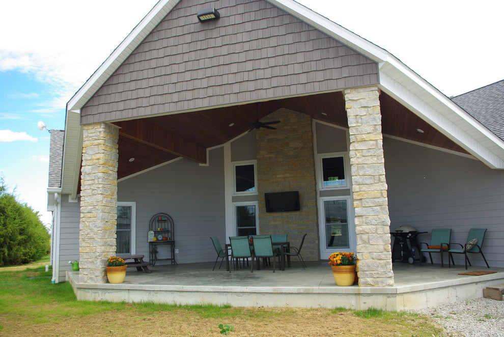 Foto di un grande patio o portico country davanti casa con un tetto a sbalzo e pavimentazioni in cemento