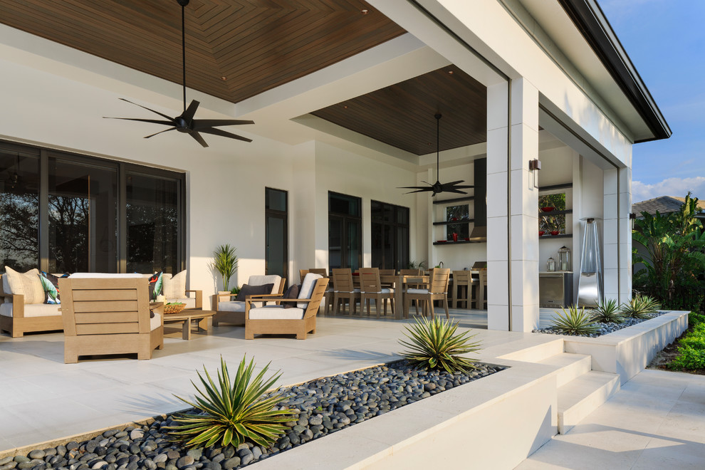 Пример оригинального дизайна: большой двор на заднем дворе в стиле модернизм с летней кухней, покрытием из плитки и навесом
