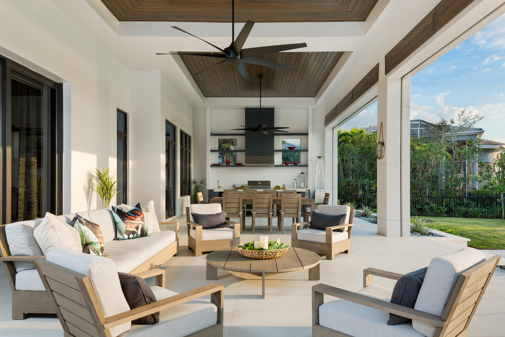 Inspiration for a large modern back patio in Miami with an outdoor kitchen, tiled flooring and a roof extension.